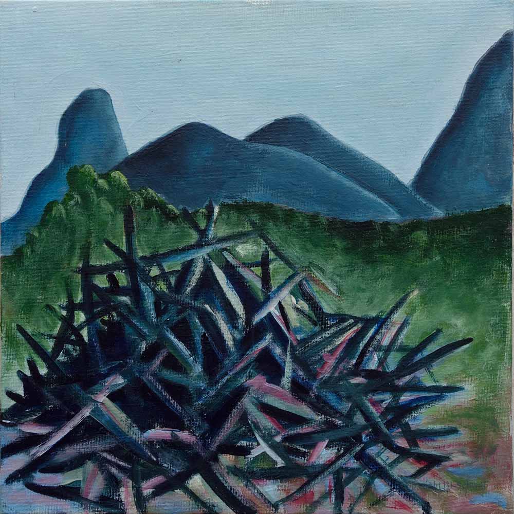 A landscape painting featuring a stack of dark sticks and branches in the foreground, with a backdrop of rolling blue mountains under a light blue sky.